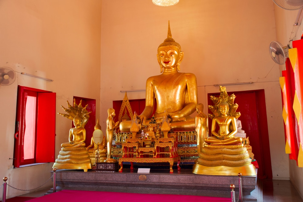 พระพุทธรูปทองคำองค์ใหญ่ประทับอยู่กลางห้องในวัดสว่างอารมณ์ ขนาบข้างด้วยพระพุทธรูปทองคำองค์เล็กอีก 2 องค์ รูปปั้นเหล่านี้วางอยู่บนแท่นยกสูงพร้อมการตกแต่งอย่างหรูหรา วัดศาลเจ้าเซียนแปะโรงสี