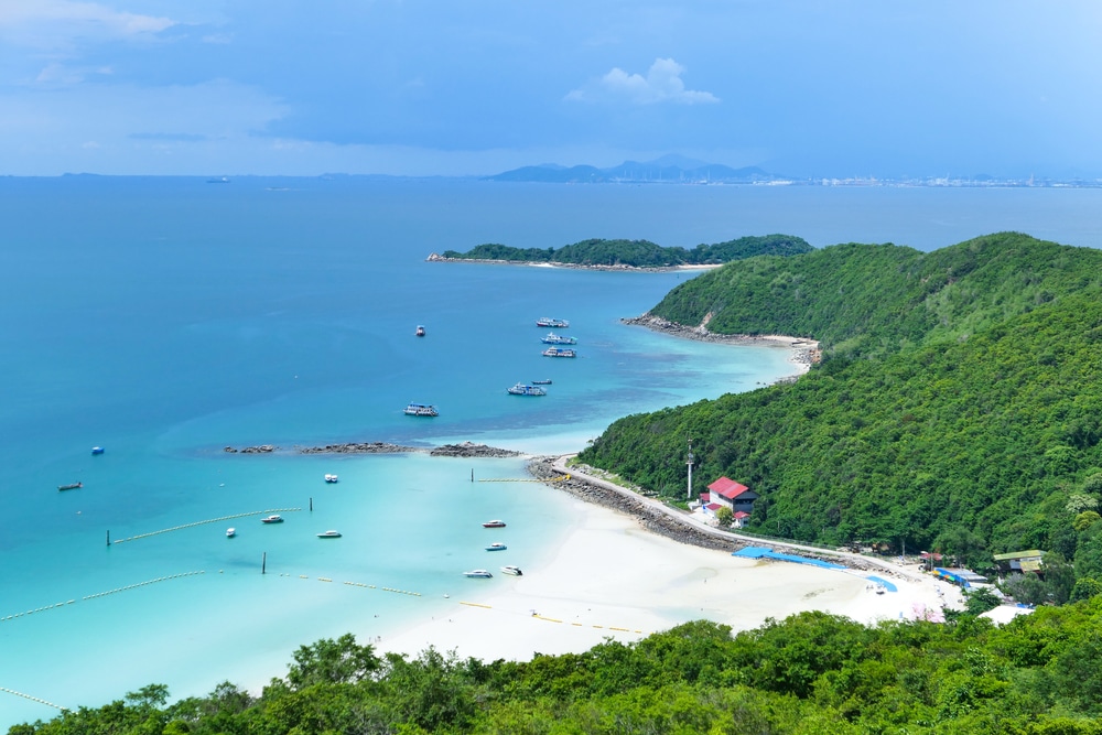 ทิวทัศน์อันงดงามของภูมิทัศน์ชายฝั่งประกอบด้วยน้ำทะเลสีฟ้าคราม หาดทราย เรือที่จอดทอดสมออยู่ใกล้ชายฝั่ง และเนินเขาที่ปกคลุมด้วยป่าไม้ทอดยาวไปจนสุดขอบฟ้า สะท้อนถึงแก่นแท้ของเกาะต่างๆ ในประเทศไทยในประเทศไทย เกาะที่สวยที่สุดในประเทศไทย