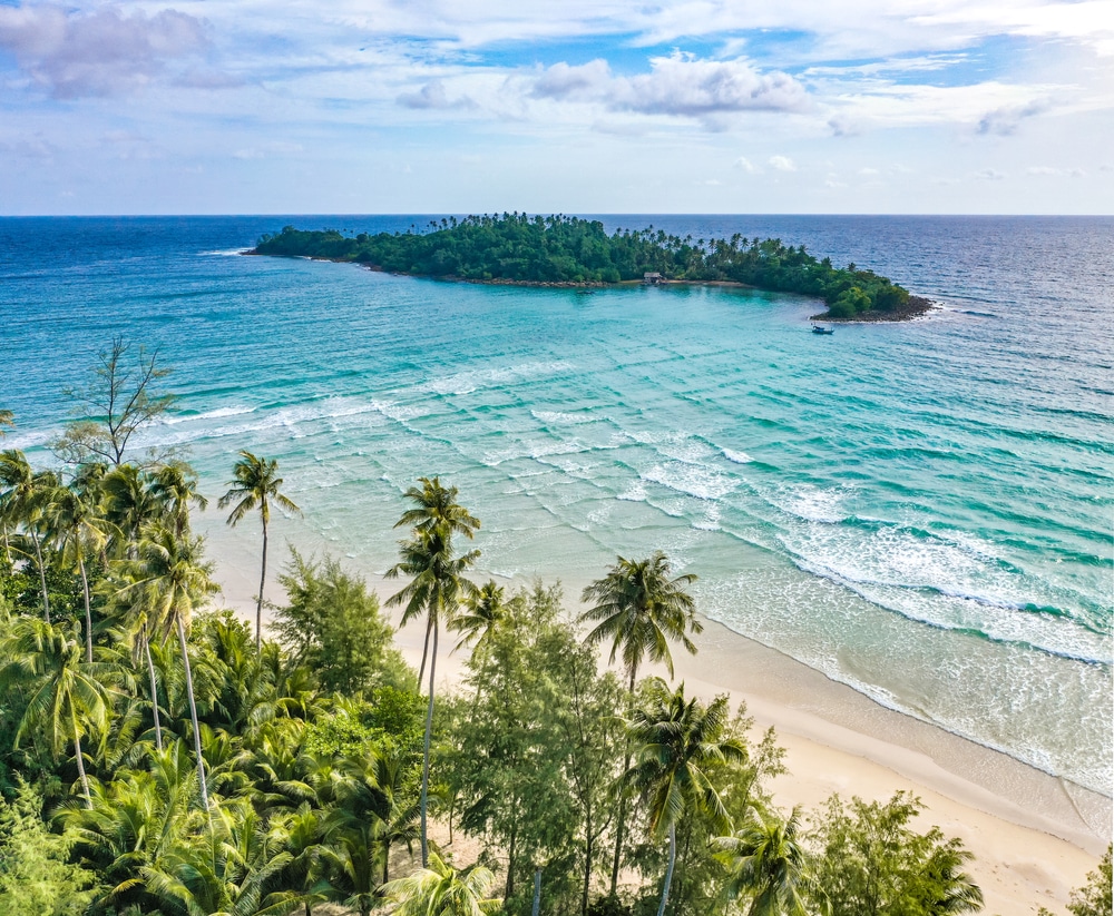 วิวทางอากาศของเกาะเขตร้อนที่ล้อมรอบด้วยน้ำทะเลสีฟ้าคราม พร้อมด้วยหาดทรายและต้นปาล์ม ถือเป็นสถานที่ท่องเที่ยวที่สมบูรณ์แบบสำหรับคู่รัก เที่ยวเมืองรอง