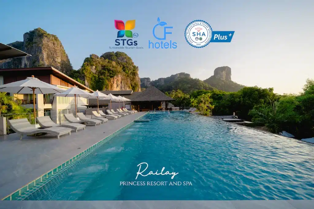 บรรยากาศริมสระน้ำอันเงียบสงบที่ Railay Princess Resort and Spa ที่พักผ่อนภาคใต้ ล้อมรอบไปด้วย ที่พักผ่อนภาคใต้ ต้นไม้เขียวขจีและหน้าผาหิน มีสระว่ายน้ำสีฟ้าใสรายล้อมไปด้วยเก้าอี้นั่งเล่นและร่มกันแดด