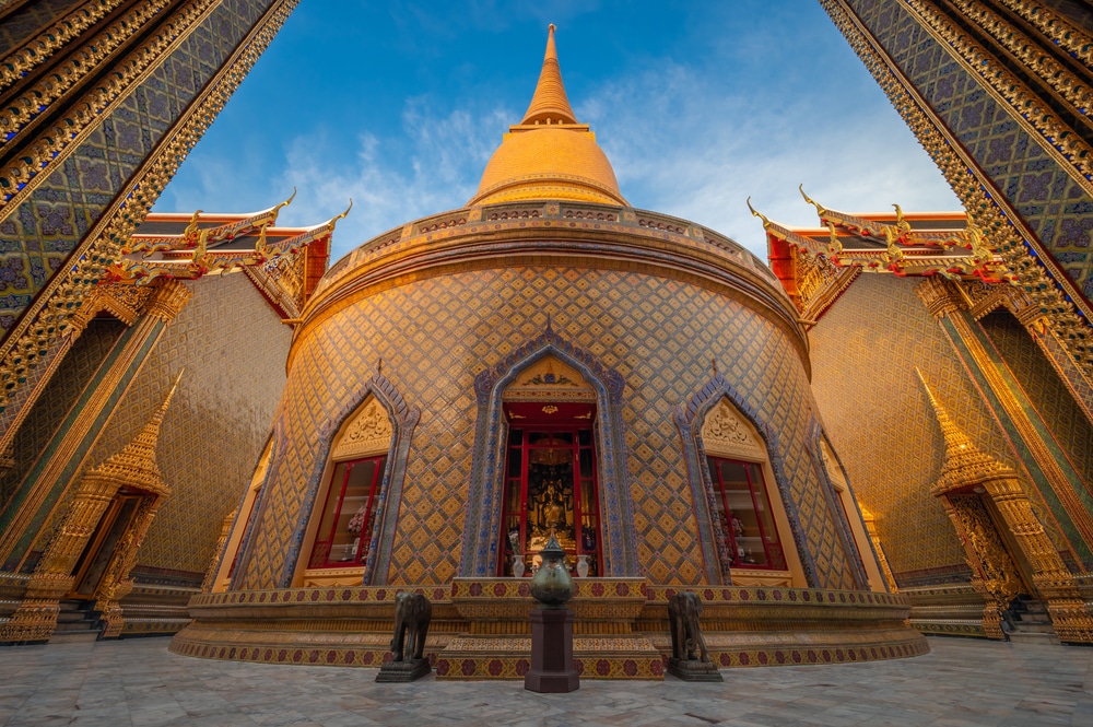 เจดีย์สีทองที่วัดพระแก้วหรือที่เรียกอีกอย่างหนึ่งว่าวัดพระแก้ว ในกรุงเทพมหานคร ประเทศไทย รายล้อมด้วยสถาปัตยกรรมอันประณีตและท้องฟ้าสีฟ้าใส เป็นภาพที่เงียบสงบ โดยเฉพาะในช่วง วันมาฆบูชา