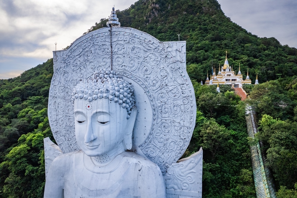 มุมมองทางอากาศ วัดสวยลพบุรี ของพระพุทธรูปสีขาวองค์ใหญ่แกะสลักอย่างประณีตด้านหน้าวัดบนยอดเขาที่วัดสวยลพบุรี รายล้อมไปด้วยต้นไม้เขียวขจี