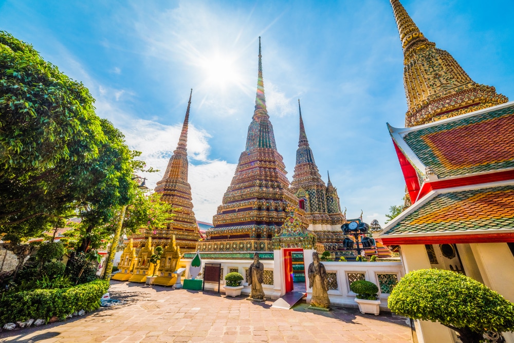 พระมหาเจดีย์ศรีรัชการที่วัดโพธิ์ในกรุงเทพฯ ติด วัดที่สวยที่สุดในประเทศไทย กับวัดพระนอนอันโด่งดัง มียอดแหลมและรูปปั้นอันหรูหราภายใต้ท้องฟ้าสีครามสดใส.