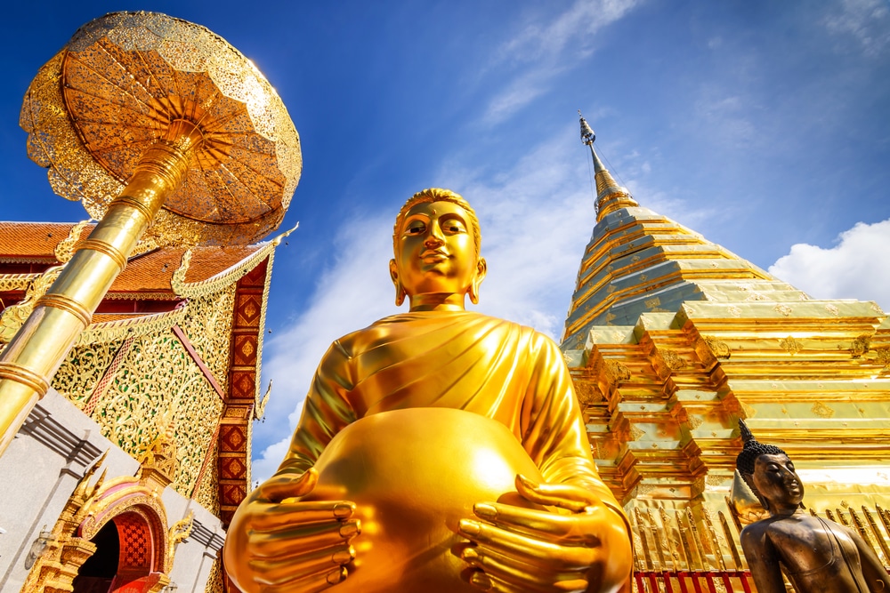 พระพุทธรูปสีทองตั้งตระหง่านอย่าง วัดที่สวยที่สุดในประเทศไทย สง่างามท่ามกลางสถาปัตยกรรมอันวิจิตรงดงามภายใต้ท้องฟ้าสีน้ำเงินสดใส โดยมีเจดีย์สีทองของวัดพระนอนเป็นฉากหลัง เป็นการเชิญชวนผู้แสวงหาการไตร่ตรองทางจิตวิญญาณอย่างสงบ.