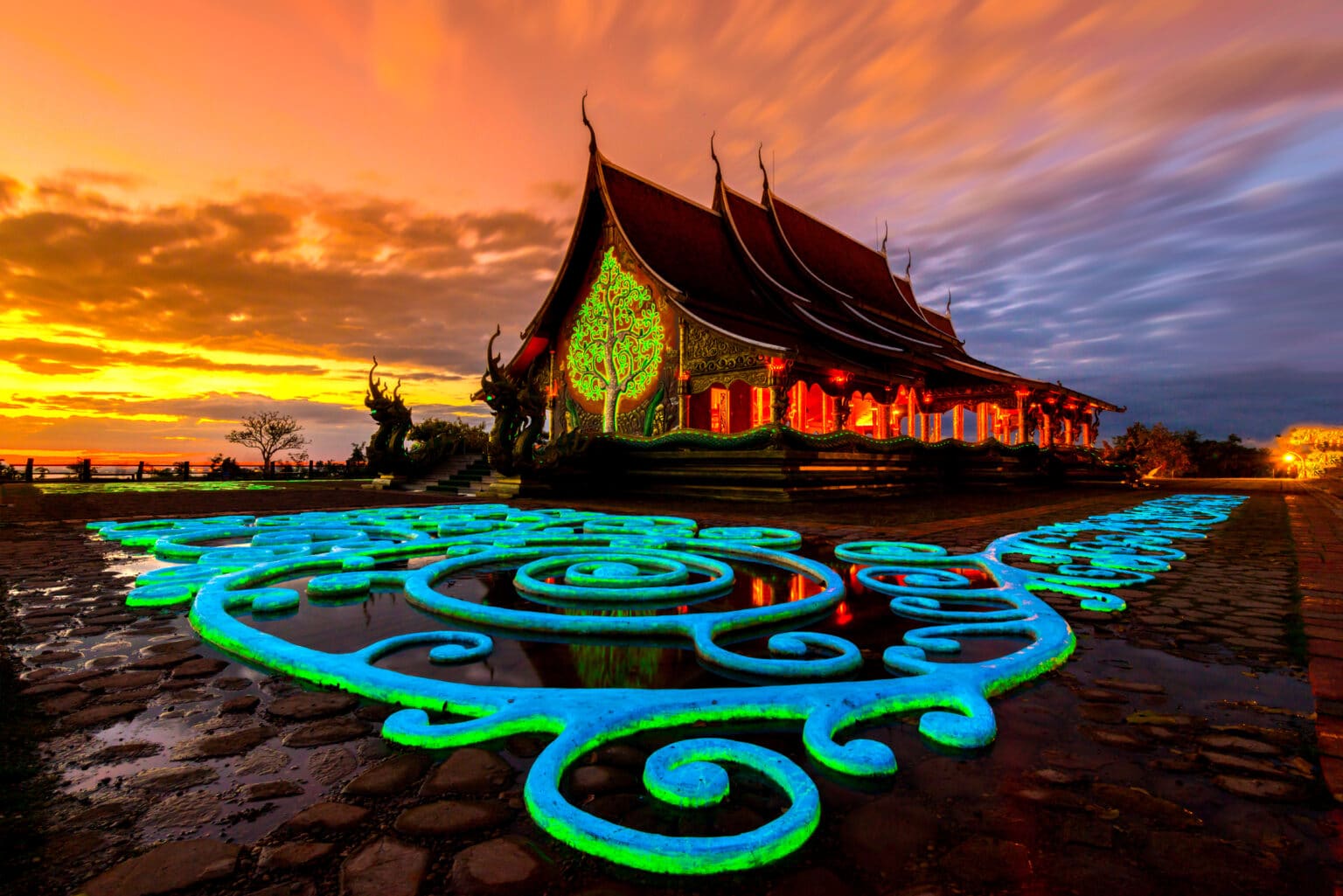 วัดพระนอนมีลวดลายเรืองแสงบนพื้นตั้งตระหง่านตัดกับท้องฟ้าพระอาทิตย์ตกสีส้มและสีเทา รายละเอียดทาง วัดที่สวยที่สุดในประเทศไทย สถาปัตยกรรมที่ซับซ้อนและสีสันที่สดใสเชิญชวนให้ผู้มาเยือนมาไหว้พระนอนในบรรยากาศอันเงียบสงบและเป็นจิตวิญญาณ.