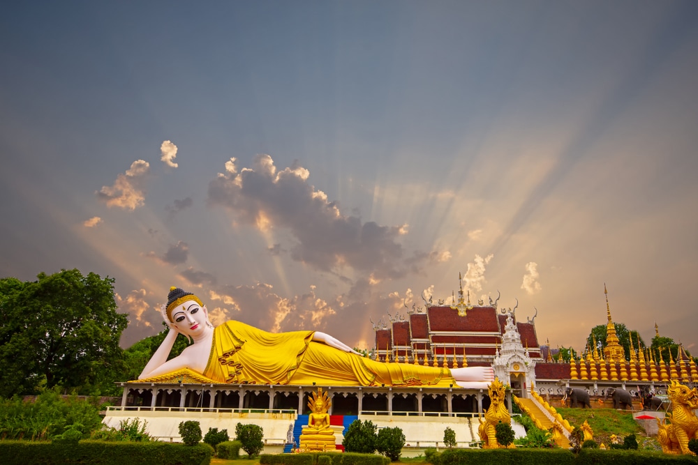 พระพุทธรูปนอนองค์ใหญ่ที่วัดพระนอน ตั้งตระหง่านอยู่หน้าวิหาร มีหลังคาประดับประดาอย่างวิจิตร วัดที่สวยที่สุดในประเทศไทย งดงาม ล้อมรอบด้วยรูปปั้น และได้รับการสักการะภายใต้ท้องฟ้าอันสวยงามที่มีแสงแดดส่องถึง ผู้มาเยี่ยมชมมักมาไหว้พระนอนเพื่อแสวงหาความสงบและความสบายใจทางจิตวิญญาณ.