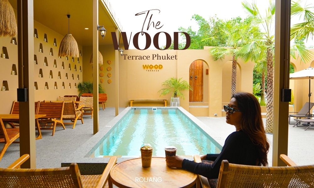 หญิงสาวกำลังพักผ่อนที่ The Wood Terrace Phuket จิบเครื่องดื่มและเพลิดเพลินไปกับทัศนียภาพอันเงียบสงบของสระว่ายน้ำในบรรยากาศกลางแจ้งอันเงียบสงบ.