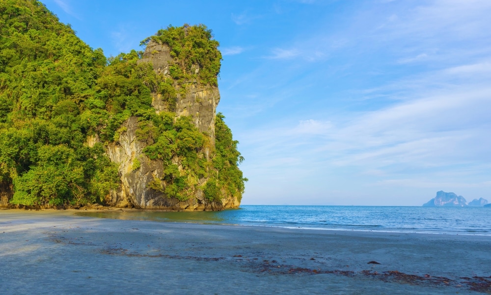 หาดทรายในจังหวัดชุมพรที่มีน้ำ ที่เที่ยวตรัง ทะเลสีฟ้าใสล้อมรอบด้วยหน้าผาเขียวขจีใต้ท้องฟ้าสีครามสดใส ที่ท่องเที่ยวชุมพรอันน่าทึ่งแห่งนี้มอบการหลีกหนีอันเงียบสงบ.