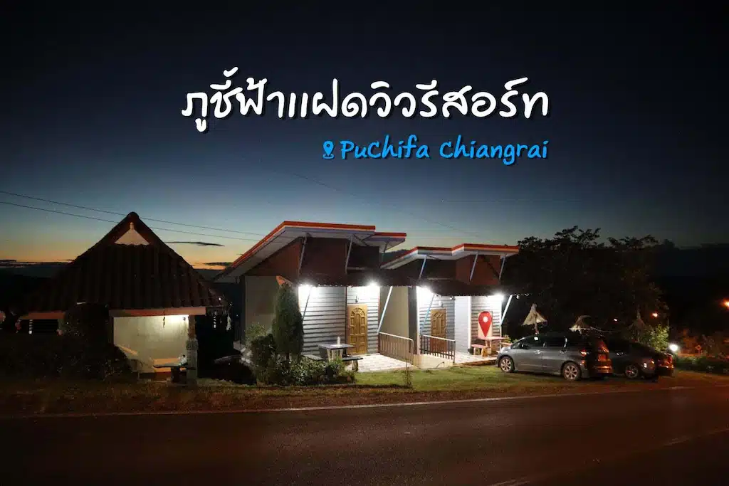 ในเวลาพลบค่ำอาคารชื่อ "ภูชีฟ้า  ที่พักภูชี้ฟ้า เชียงราย" ให้บรรยากาศเงียบสงบ มีแสงไฟอ่อนๆ ข้างต้นไม้ริมถนน จุดนี้ช่วยให้เห็นภาพของภูชี้ฟ้าที่น่าดึงดูดใจสำหรับผู้ที่สำรวจพื้นที่.