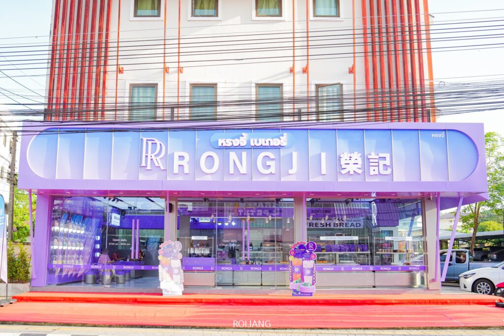 หน้าร้านสีม่วงสดใสของร้านเบเกอรี่ RONGJI ตกแต่งด้วยการ์ตูนและด้านหน้าร้านเป็นกระจกที่ทันสมัย.