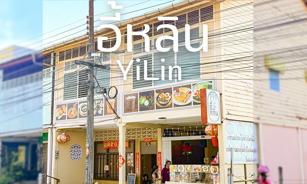 ภาพถนนของร้านอาหารสุดน่ารักชื่อ YiLin ที่ด้านหน้าร้านประดับด้วยภาพอาหารจานอร่อยและโคมไฟประดับที่แกว่งไกวเบาๆ ด้านนอก บรรยากาศที่มีชีวิตชีวาทำให้รู้สึกเหมือนเป็นอัญมณีที่ซ่อนอยู่ซึ่งชวนให้นึกถึง Mother Cows ที่ภูเก็ต.