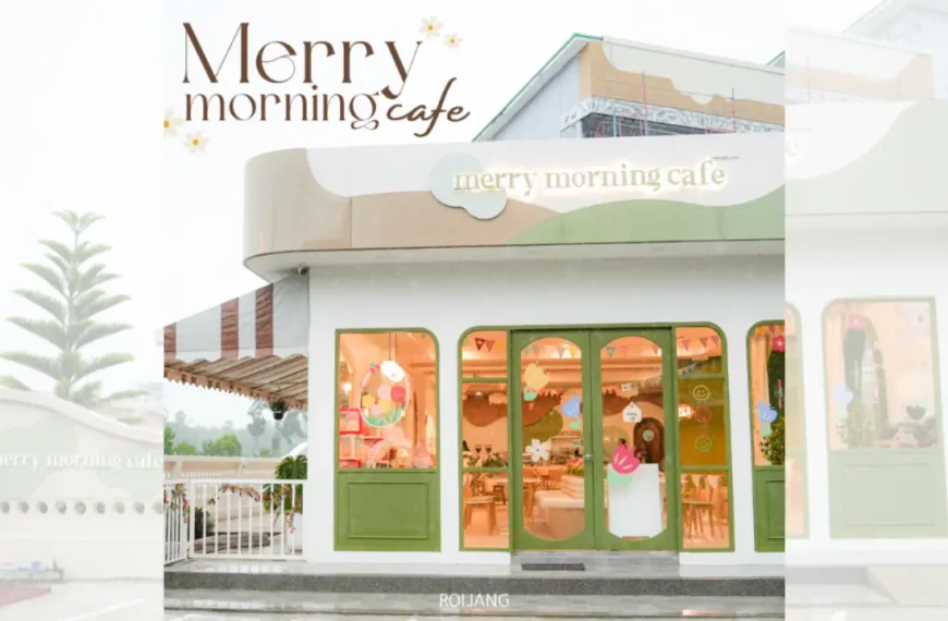 ร้านกาแฟสีขาวและสีเขียวที่มีหน้าต่างบานใหญ่และป้ายเขียนว่า “Merry Morning Cafe” โดยมีคนยืนอยู่ที่ทางเข้า เชิญชวนแขกให้เริ่มต้นวันใหม่ในจุดร่าเริงนี้.