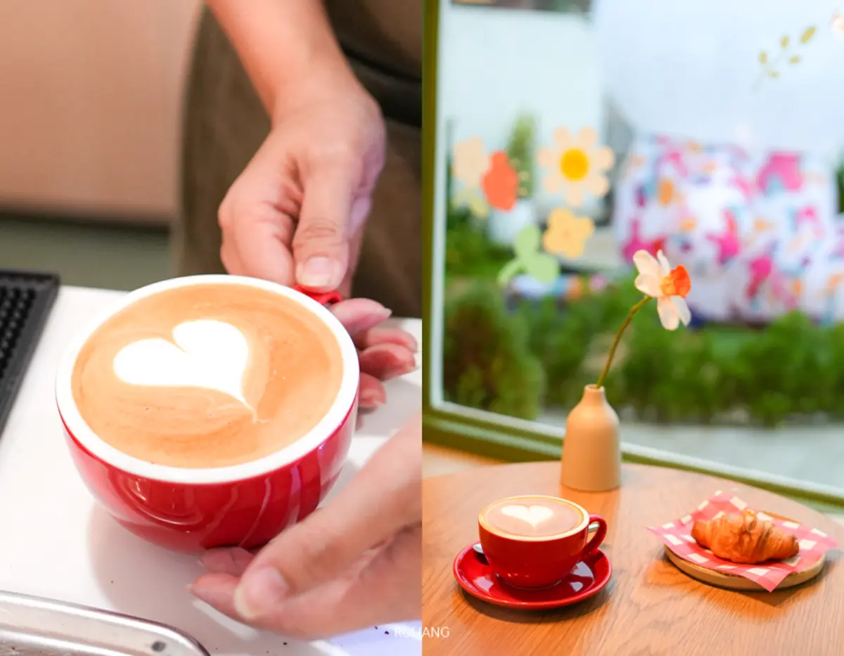 ที่ Merry Morning Cafe คนๆ หนึ่งถือแก้วลาเต้สีแดงที่มีภาพเขียนรูปหัวใจ ข้างๆ กันนั้นยังมีโต๊ะวางลาเต้อีกแก้ว ครัวซองต์ และแจกันเล็กที่มีดอกไม้ใกล้หน้าต่าง.