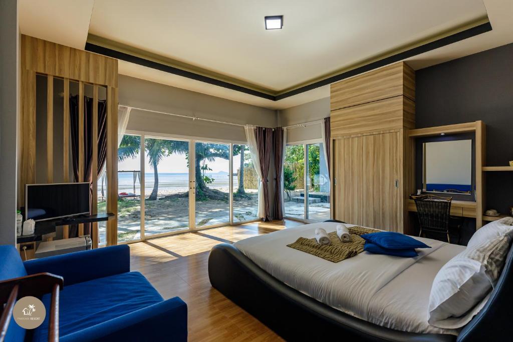 ห้องนอนทันสมัย พร้อมหน้าต่างบานใหญ่ที่มองเห็นวิวชายหาดและ ที่พักสตูลแนวธรรมชาติ มหาสมุทร มีเตียงใหญ่ โต๊ะทำงาน ทีวี และพื้นที่นั่งเล่น สัมผัสแสงธรรมชาติที่ส่องเข้ามาในห้องนี้โดยไม่ต้องสตูลแนวธรรมชาติเพื่อการพักผ่อนอย่างแท้จริง.