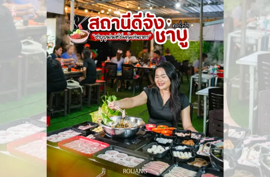 ผู้หญิงคนหนึ่งนั่งอยู่ที่โต๊ะกลางแจ้ง กำลังปรุงเนื้อสัตว์และผักต่าง ๆ บนเตาปิ้งย่างร้อน ๆ ที่ สถานีดีจัง ล้อมรอบด้วยจานอาหารหลายอย่าง และมีผู้รับประทานอาหารคนอื่น ๆ อยู่เบื้องหลัง.