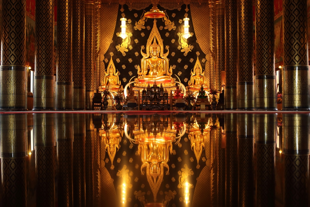 พระพุทธรูปทองคำถูกจัดแสดงบนแท่นบูชาที่ประดับประดาอย่างวิจิตรในวัดที่มีเสาสูงประดับตกแต่งอย่าง ที่เที่ยวเลย สวยงามและพื้นขัดมันเงางามสะท้อนภาพบรรยากาศ—เป็นสถานที่ที่ไม่ควรพลาดสำหรับผู้ที่กำลังค้นหา ที่เที่ยวเลย.