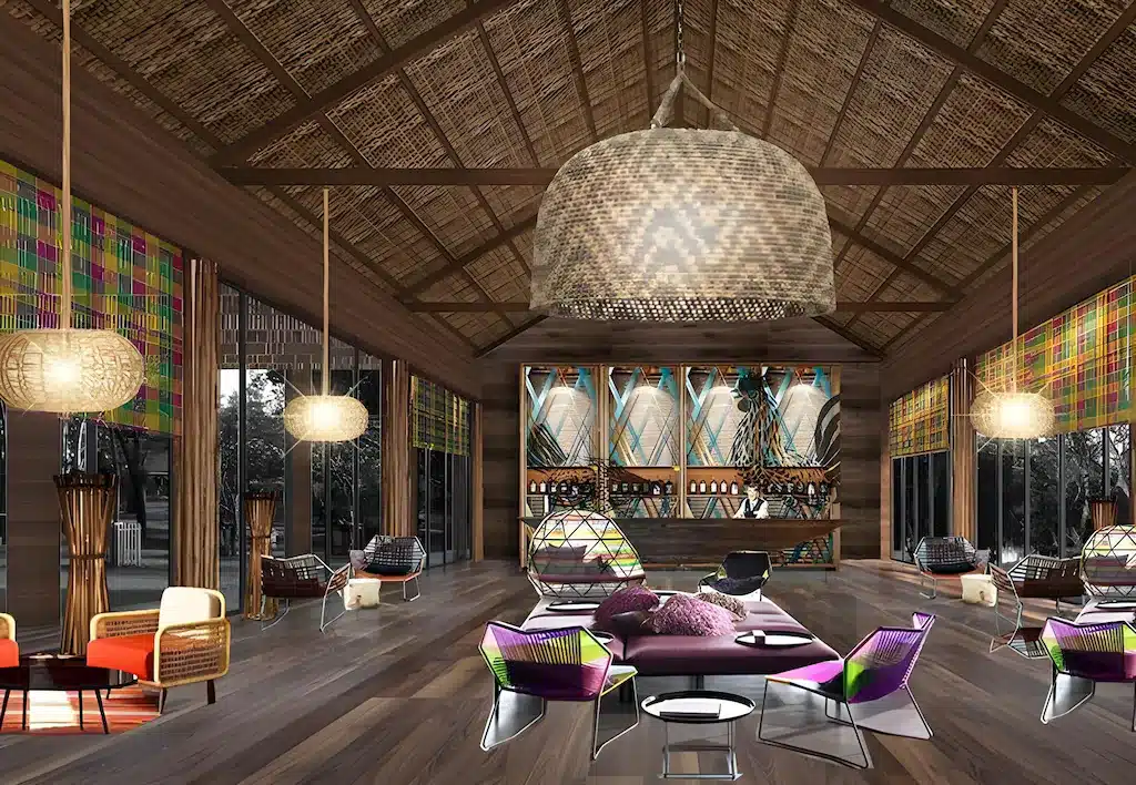 ล็อบบี้กว้างขวางพร้อมพื้นไม้ เพดานโค้งสูง โคมไฟสาน และเฟอร์นิเจอร์ ที่พักเขาใหญ่ ทันสมัยสีสันสดใส—เหมาะสำหรับการพักผ่อนที่ โรงแรมเขาใหญ่ ที่มีสไตล์ หรือผู้ที่มองหา ที่พักเขาใหญ่ ที่มีดีไซน์โดดเด่นไม่เหมือนใคร.