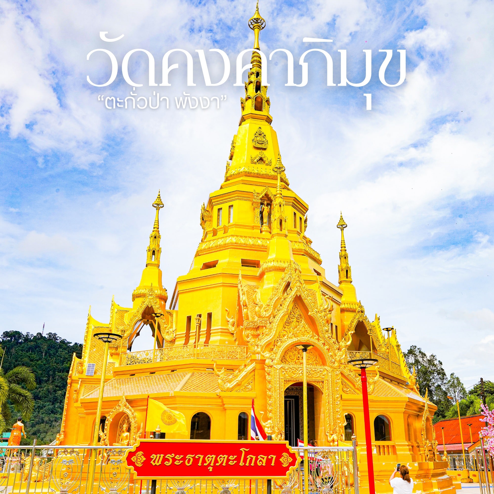วิหารทองคำประดับลวดลายวิจิตรและยอดแหลม ตั้งตระหง่านตัดกับท้องฟ้าสดใส พร้อมข้อความภาษาไทยและป้ายสีแดงอยู่เบื้องหน้า—สถานที่ท่องเที่ยวชื่อดังของ เที่ยวตะกั่วป่า ที่ไม่ควรพลาด.