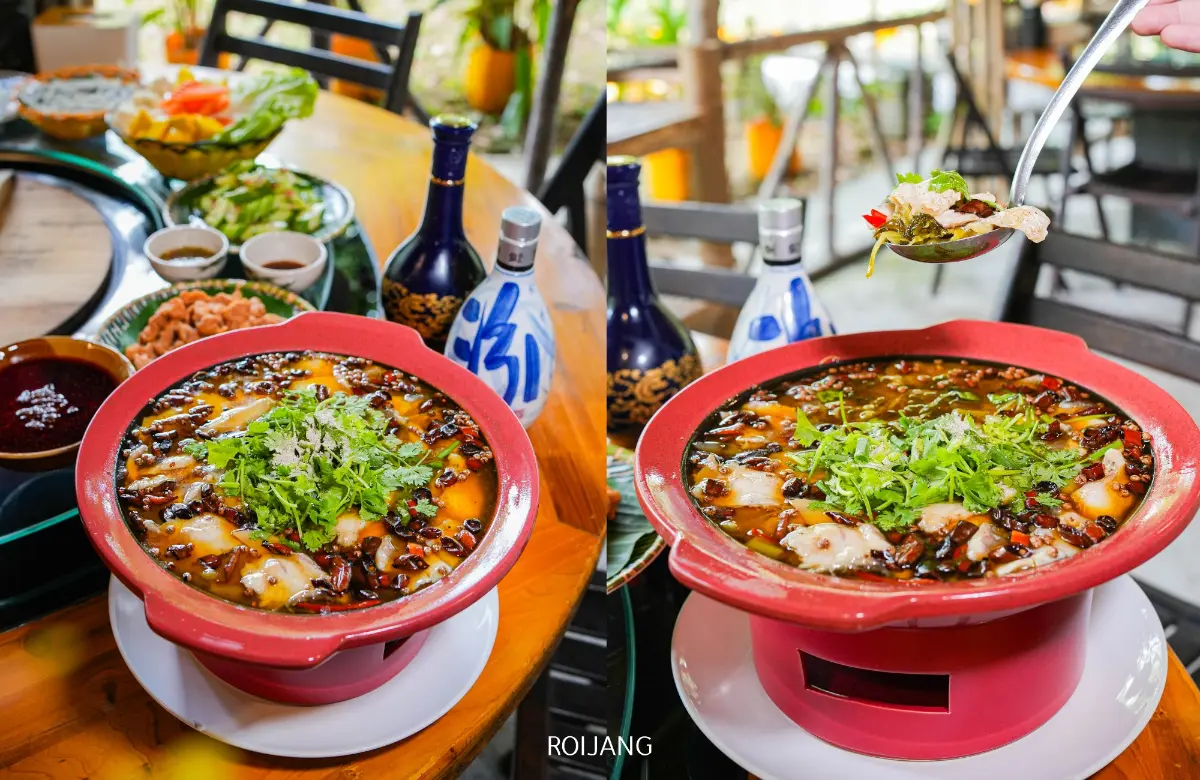 หม้อไฟไก่ไฟฟืนร้อน ๆ พร้อมน้ำซุป สมุนไพร และเนื้อสัตว์วางอยู่บนโต๊ะ ล้อมรอบด้วยเครื่องเคียงและเครื่องดื่ม ช้อนตักส่วนผสมที่นุ่มลิ้นออกจากหม้อที่ยังคงมีไอร้อนลอยขึ้น.