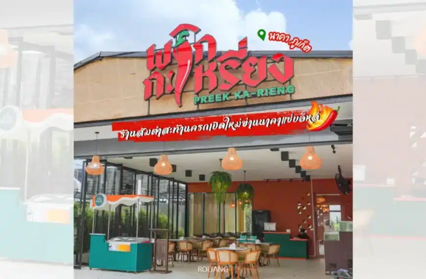 ภาพภายนอกของร้านอาหาร พริกกะเหรี่ยง ภูเก็ต พร้อมที่นั่งกลางแจ้ง ผนังกระจก และป้ายขนาดใหญ่ในภาษาไทยเหนือทางเข้าที่แสดงชื่อร้านอย่างภาคภูมิใจว่า