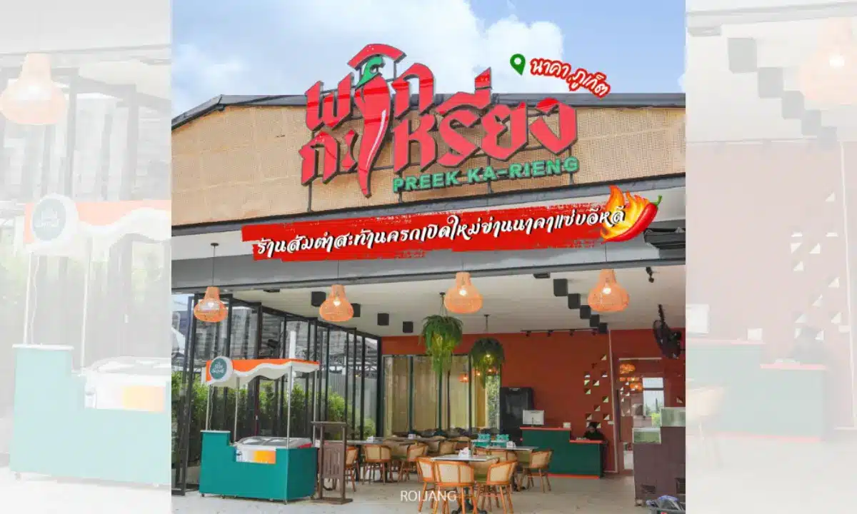 ภาพภายนอกของร้านอาหาร พริกกะเหรี่ยง ภูเก็ต พร้อมที่นั่งกลางแจ้ง ผนังกระจก และป้ายขนาดใหญ่ในภาษาไทยเหนือทางเข้าที่แสดงชื่อร้านอย่างภาคภูมิใจว่า