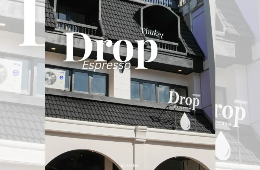 ภายนอกของอาคารที่มีหลังคากระเบื้องสีดำและระเบียง มีป้าย "Drop Espresso Phuket" ติดอยู่ใกล้กับเครื่องปรับอากาศสองเครื่อง ให้บรรยากาศที่มีสไตล์คล้ายกับ