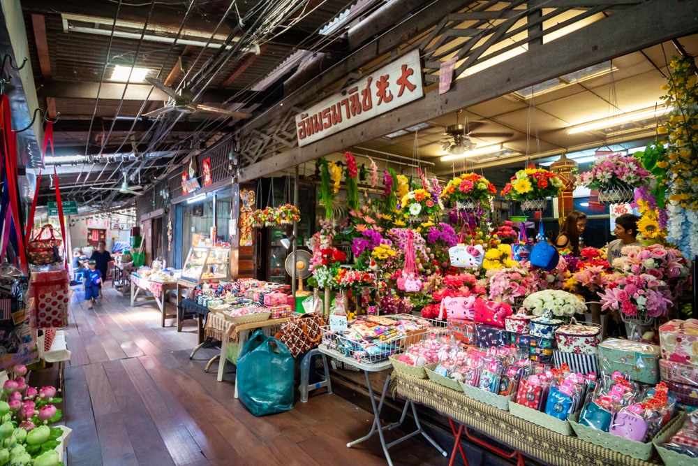 ตลาดในร่มที่มีชีวิตชีวาพร้อมพื้นไม้ ร้านค้าขายดอกไม้สีสันสดใส กระเป๋า และสินค้าหลากหลาย ดึงดูดนักช้อปที่กำลังมองหาของแปลกใหม่—จุดแวะพักที่เหมาะสำหรับผู้ที่กำลังสำรวจ ที่เที่ยวบางปู หรือวางแผน เที่ยวบางปู.