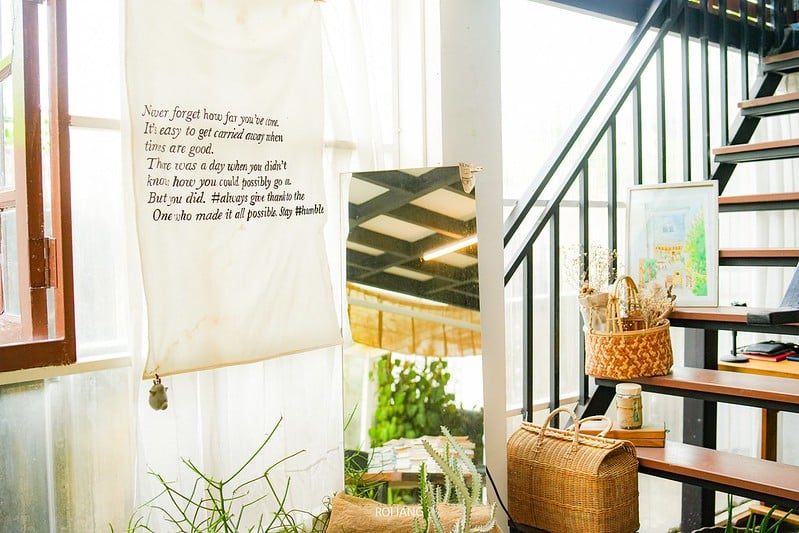 บรรยากาศภายในที่อบอุ่นได้รับแรงบันดาลใจจาก คาเฟ่ภูเก็ต ประกอบด้วยคำคมบนผนัง กระจกบานใหญ่ ต้นไม้ ตะกร้าสาน อุปกรณ์ศิลปะ และบันไดที่มีงานศิลปะติดกรอบอยู่ข้างๆ แสงธรรมชาติส่องเข้ามาเติมเต็มพื้นที่อันน่าดึงดูดนี้.