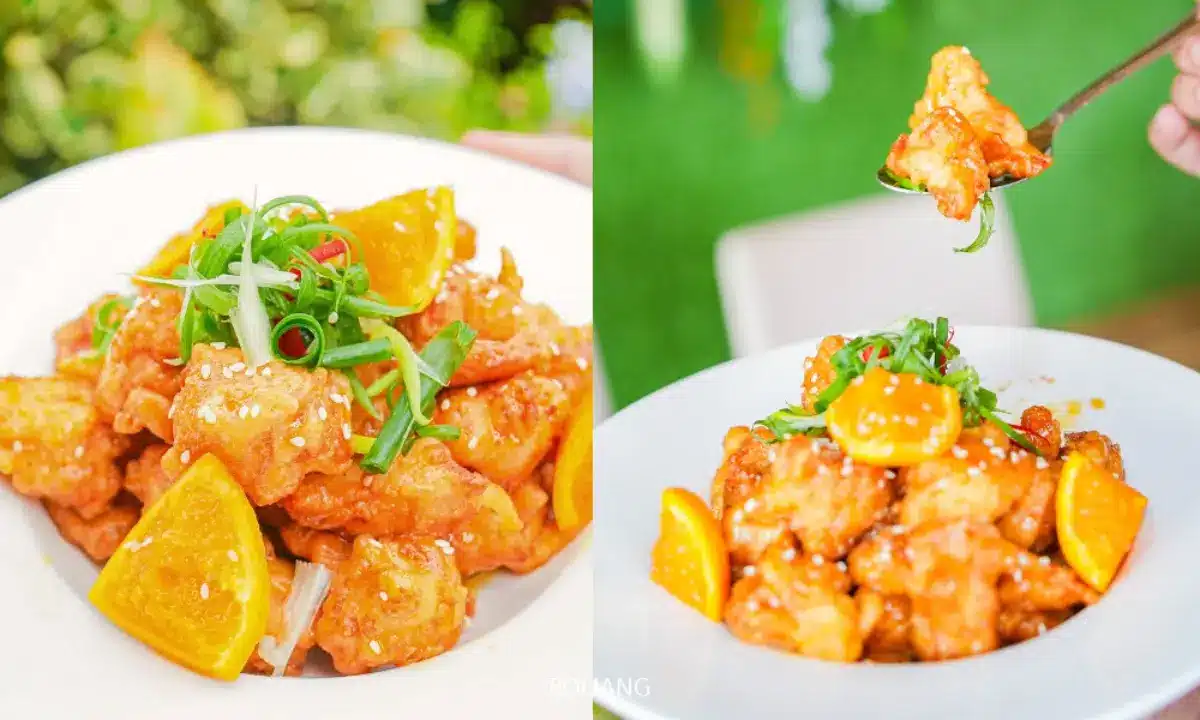 จานไก่ส้มสองจานตกแต่งด้วยต้นหอม, ส้มหั่นแว่น, และงา; หนึ่งจานเสิร์ฟพร้อมส้อมที่ Cynthia เขาหลัก.