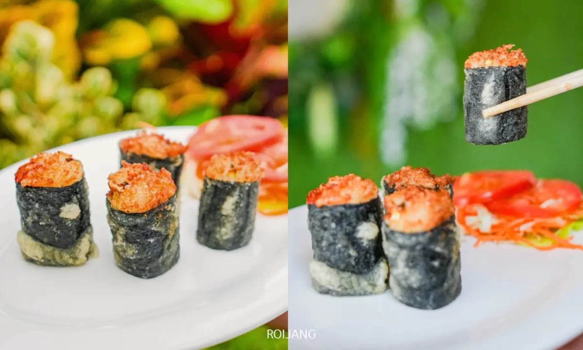 ซูชิสี่ชิ้นที่โรยด้วยส่วนผสมรสเผ็ดวางอยู่บนจานสีขาวพร้อมกับมะเขือเทศหั่นแว่นที่ Cynthia เขาหลัก; ชิ้นหนึ่งกำลังถูกยกขึ้นด้วยตะเกียบ.