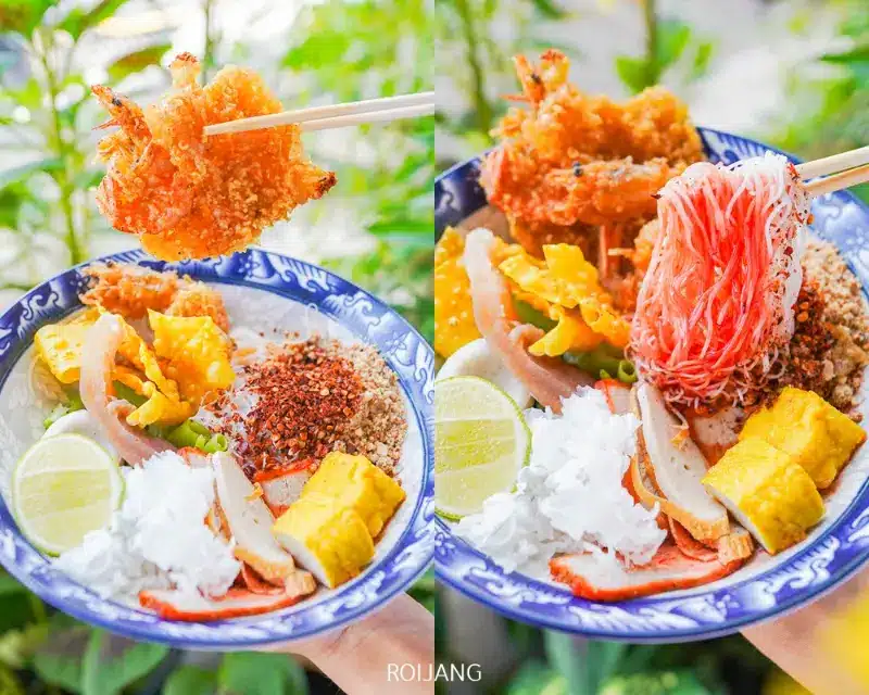 ชามฟูเย็นตาโฟที่มีส่วนผสมหลากหลาย เช่น กุ้งทอด เส้นก๋วยเตี๋ยว มะนาว ไข่ และไม้ปู พร้อมตะเกียบที่ถือกุ้งอยู่ทางซ้ายและเส้นก๋วยเตี๋ยวอยู่ทางขวา.