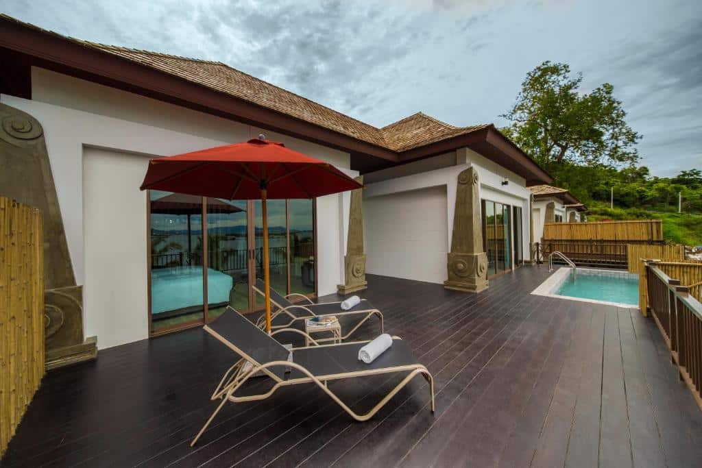 วิลล่าสมัยใหม่พร้อมลานระเบียงที่มีเก้าอี้เลานจ์สองตัว ร่มสีแดง สระว่ายรวม ที่เที่ยวเกาะสีชัง เกาะสวยๆ ในที่เที่ยวชลบุรี ไป เที่ยวเกาะสีชัง เดินทางง่ายๆ ใกล้กรุงเทพแบบไปเช้าเย็นกลับได้ หลีกหนีความวุ่นวาย พร้อมอวดสถานที่สโลว์ไลฟ์
น้ำส่วนตัว และประตูกระจกบานเลื่อนขนาดใหญ่—เหมาะสำหรับการพักผ่อนหลังจากวันที่สำรวจสถานที่ท่องเที่ยวเกาะสีชัง ทั้งหมดล้อมรอบด้วยรั้วและพืชพรรณเขียวชอุ่มภายใต้ท้องฟ้าที่มีเมฆครึ้ม.