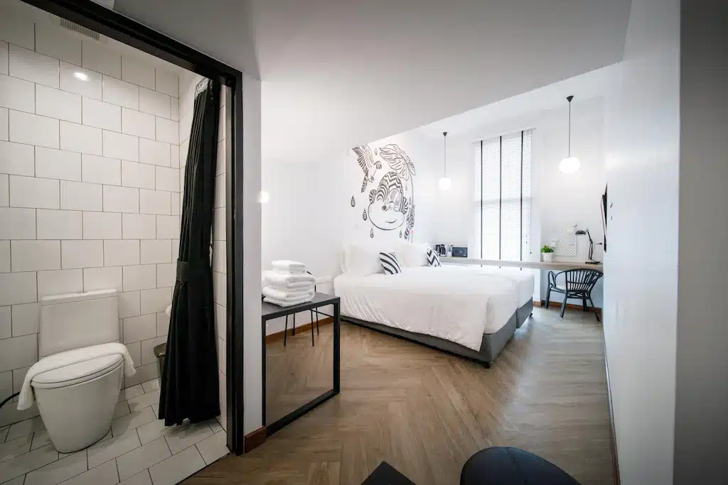 ห้องพัก โรงแรมระนอง มสมัยใหม่ใน โรงแรมระนอง พร้อมเตียงคู่, ศิลปะติดผนัง, โต๊ะทำงาน และเก้าอี้; ห้องน้ำติดกันพร้อมห้องสุขาและฝักบัว. เพลิดเพลินกับการตกแต่งแบบมินิมอลด้วยโทนสีกลาง ๆ เหมาะสำหรับนักเดินทางที่ต้องการ ที่พักระนองในเมือง.