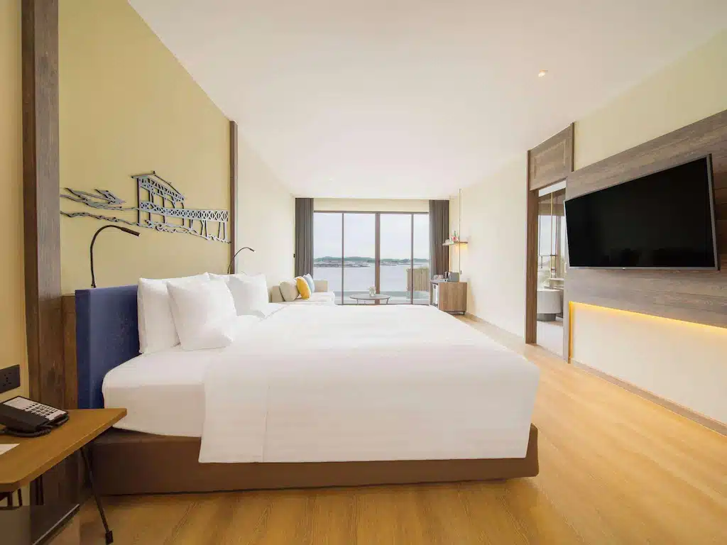 ห้องพักโรงแรมสมัยใหม่พร้อมเตียงขนาดใหญ่ ทีวีติดผนัง พื้นไม้ และหน้าต่างบานใหญ่จากพื้นจรดเพดานรวม ที่เที่ยวเกาะสีชัง เกาะสวยๆ ในที่เที่ยวชลบุรี ไป เที่ยวเกาะสีชัง เดินทางง่ายๆ ใกล้กรุงเทพแบบไปเช้าเย็นกลับได้ หลีกหนีความวุ่นวาย พร้อมอวดสถานที่สโลว์ไลฟ์
ที่มองเห็นวิวทะเล—เหมาะสำหรับนักเดินทางที่สำรวจ เที่ยวเกาะสีชัง หรือค้นพบ ที่เที่ยวเกาะสีชัง.