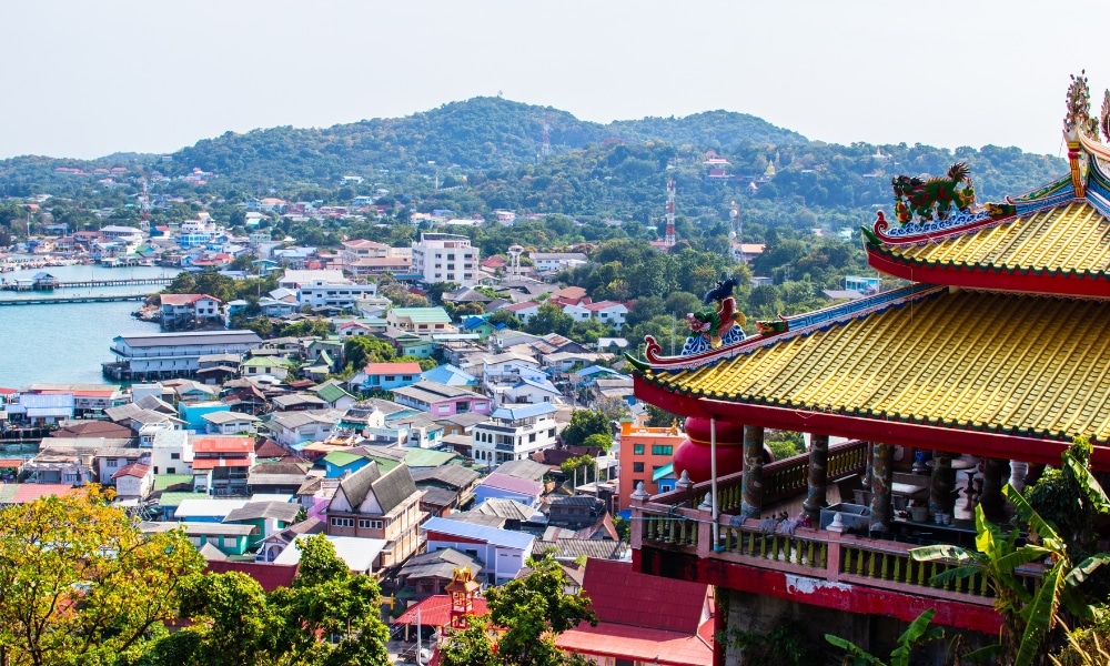 เพลิดเพลินกับทัศนียภาพอันงดงามของเมืองชายฝั่งที่เต็มไปด้วยสีสันบนเกาะสีชัง พร้อมด้วยวัดแบบรวม ที่เที่ยวเกาะสีชัง เกาะสวยๆ ในที่เที่ยวชลบุรี ไป เที่ยวเกาะสีชัง เดินทางง่ายๆ ใกล้กรุงเทพแบบไปเช้าเย็นกลับได้ หลีกหนีความวุ่นวาย พร้อมอวดสถานที่สโลว์ไลฟ์
ดั้งเดิมในเบื้องหน้าและภูเขาเขียวขจีในเบื้องหลัง—เหมาะสำหรับผู้ที่มองหาสถานที่ท่องเที่ยวบนเกาะสีชังภายใต้ท้องฟ้าแจ่มใส.