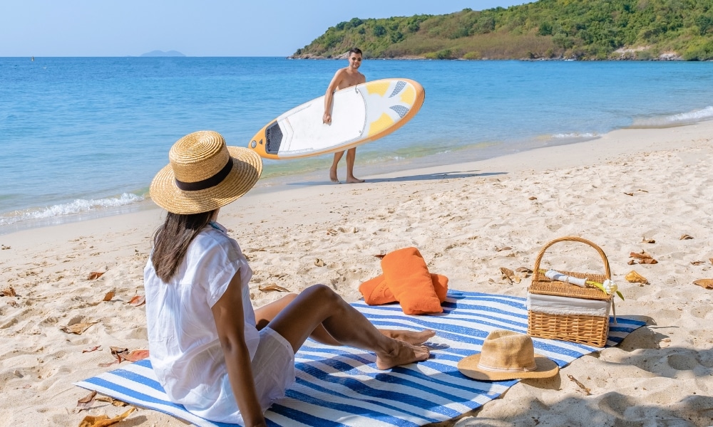 ผู้หญิงคนหนึ่งนั่งบนผ้าปูชายหาดลายทางพร้อมตะกร้าปิกนิก ขณะที่รวม ที่เที่ยวเกาะสีชัง เกาะสวยๆ ในที่เที่ยวชลบุรี ไป เที่ยวเกาะสีชัง เดินทางง่ายๆ ใกล้กรุงเทพแบบไปเช้าเย็นกลับได้ หลีกหนีความวุ่นวาย พร้อมอวดสถานที่สโลว์ไลฟ์
ผู้ชายคนหนึ่งถือแพดเดิลบอร์ดอยู่ใกล้ชายฝั่งบนชายหาดที่มีแสงแดดสดใส เหมาะสำหรับผู้ที่กำลังมองหาสถานที่ท่องเที่ยวเกาะสีชัง.