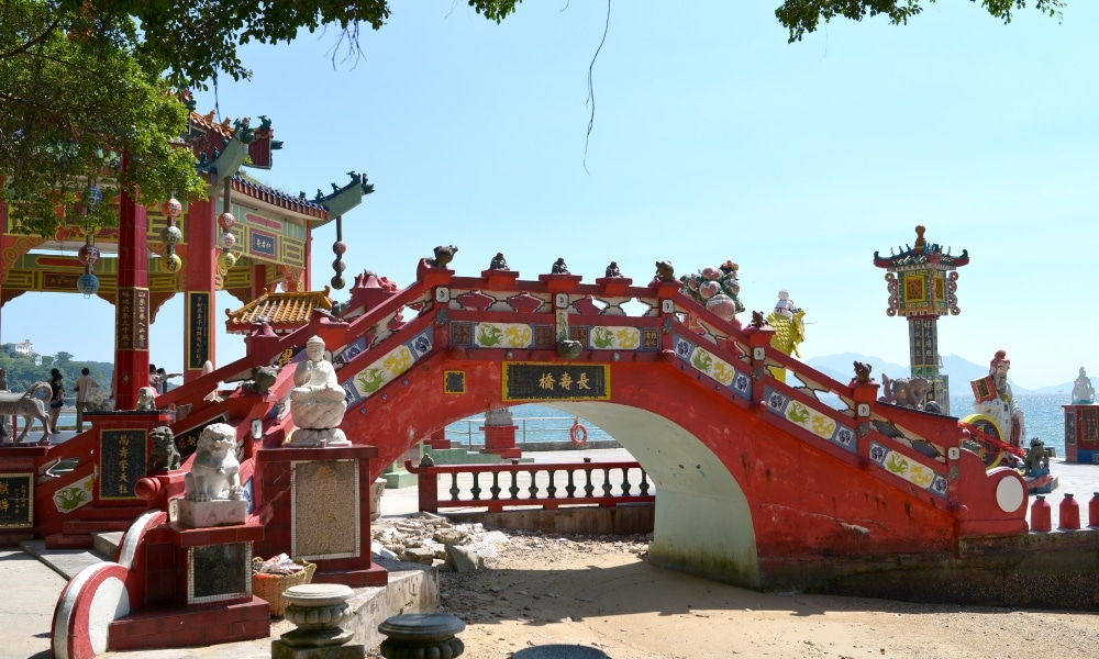 สะพานโค้งสีแดงที่มีรูปปั้นและรวม ที่เที่ยวเกาะสีชัง เกาะสวยๆ ในที่เที่ยวชลบุรี ไป เที่ยวเกาะสีชัง เดินทางง่ายๆ ใกล้กรุงเทพแบบไปเช้าเย็นกลับได้ หลีกหนีความวุ่นวาย พร้อมอวดสถานที่สโลว์ไลฟ์
กระเบื้องประดับประดาตั้งอยู่ริมน้ำในบริเวณวัดจีนแบบดั้งเดิม เป็นไฮไลท์ที่ต้องไม่พลาดสำหรับผู้ที่วางแผนจะ เที่ยวเกาะสีชัง ภายใต้ท้องฟ้าที่แจ่มใส.