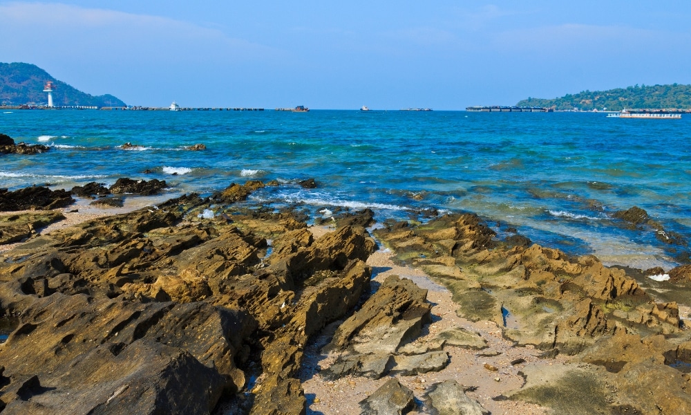 ชายฝั่งหินที่ทอดยาวพร้อมน้ำทะเลใสสีฟ้า ระลอกคลื่นเบา ๆ และท่าเรือรวม ที่เที่ยวเกาะสีชัง เกาะสวยๆ ในที่เที่ยวชลบุรี ไป เที่ยวเกาะสีชัง เดินทางง่ายๆ ใกล้กรุงเทพแบบไปเช้าเย็นกลับได้ หลีกหนีความวุ่นวาย พร้อมอวดสถานที่สโลว์ไลฟ์
ที่ตั้งอยู่ไกล ๆ ภายใต้ท้องฟ้าสดใส—เหมาะสำหรับผู้ที่ต้องการ เที่ยวเกาะสีชัง และเพลิดเพลินกับความงดงามตามธรรมชาติ.