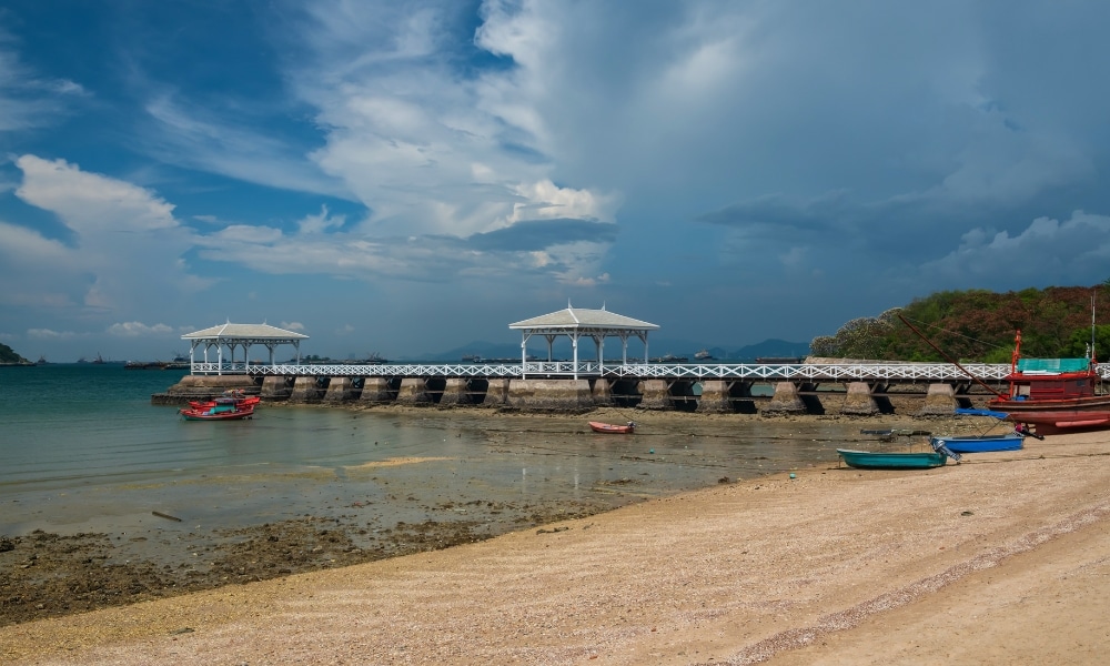 ท่าเรือสีขาวพร้อมศาลาที่ทอดยาวเหนือผืนน้ำตื้นใกล้เรือลำเล็กและชายหาดทรายใต้ท้องฟ้าที่มีเมฆบางรวม ที่เที่ยวเกาะสีชัง เกาะสวยๆ ในที่เที่ยวชลบุรี ไป เที่ยวเกาะสีชัง เดินทางง่ายๆ ใกล้กรุงเทพแบบไปเช้าเย็นกลับได้ หลีกหนีความวุ่นวาย พร้อมอวดสถานที่สโลว์ไลฟ์
ส่วน—เหมาะสำหรับผู้ที่ต้องการเที่ยวเกาะสีชังหรือสำรวจสถานที่ท่องเที่ยวบนเกาะสีชัง.