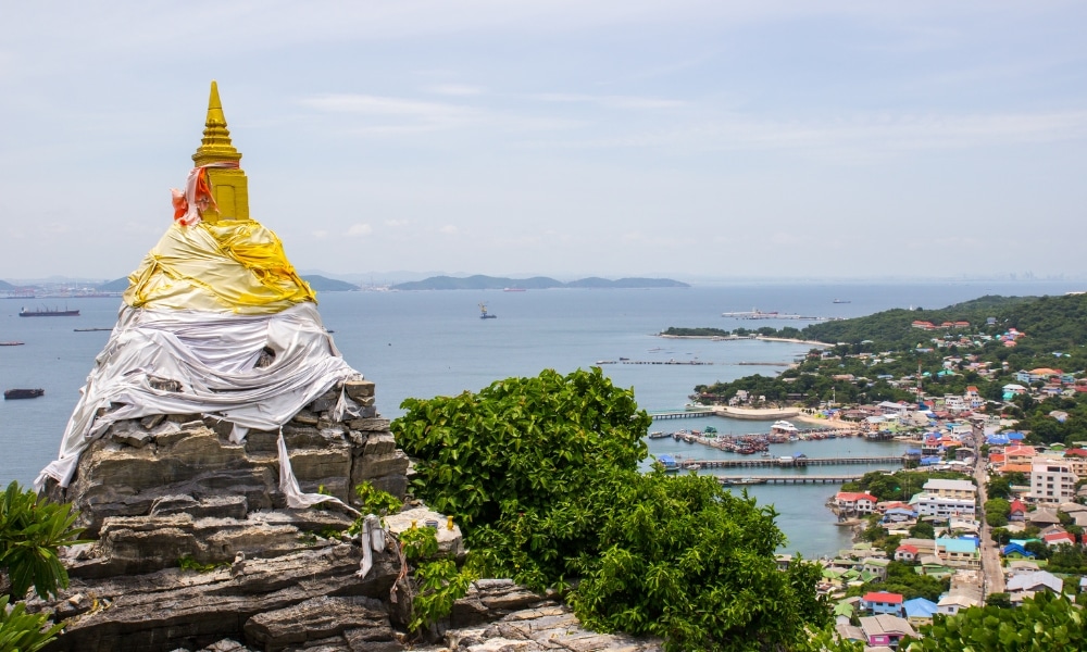 พระธาตุหุ้มผ้าตั้งอยู่บนเขาสูง มองเห็นเมืองชายฝั่งและอ่าวที่เต็มไปด้วยเรือรวม ที่เที่ยวเกาะสีชัง เกาะสวยๆ ในที่เที่ยวชลบุรี ไป เที่ยวเกาะสีชัง เดินทางง่ายๆ ใกล้กรุงเทพแบบไปเช้าเย็นกลับได้ หลีกหนีความวุ่นวาย พร้อมอวดสถานที่สโลว์ไลฟ์
และเรือใหญ่—จุดเด่นที่สงบเงียบสำหรับผู้ที่ต้องการเที่ยวเกาะสีชัง.