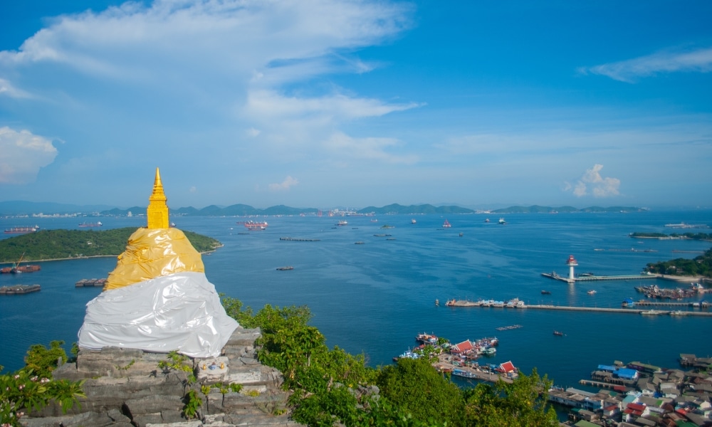 เจดีย์ทองคำขนาดเล็กห่อด้วยผ้าขาวตั้งอยู่บนเนินเขาที่มองเห็นอ่าวซึ่งมีเรือและเกาะที่อยู่ไกลออกไปภายใต้ท้องฟ้าสีคราม—หนึ่งในสถานที่ท่องรวม ที่เที่ยวเกาะสีชัง เกาะสวยๆ ในที่เที่ยวชลบุรี ไป เที่ยวเกาะสีชัง เดินทางง่ายๆ ใกล้กรุงเทพแบบไปเช้าเย็นกลับได้ หลีกหนีความวุ่นวาย พร้อมอวดสถานที่สโลว์ไลฟ์
เที่ยวบนเกาะสีชังที่ไม่ควรพลาดสำหรับผู้ที่ชื่นชอบการท่องเที่ยวเกาะสีชัง.
