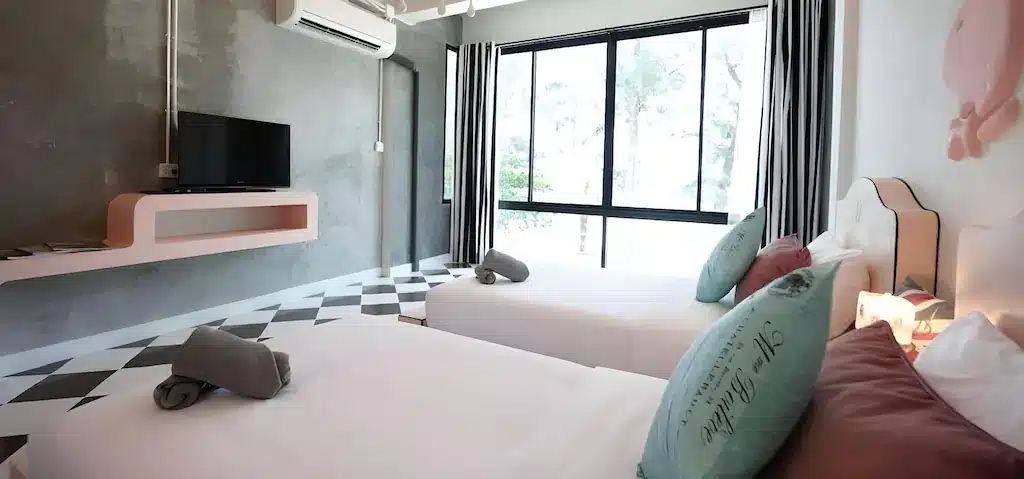 ห้องที่มีเตียงสองเตียงและโทรทัศน์ เหมาะสำหรับการพักผ่อนหลังจากสำรวจสถานที่ท่องเที่ยวชุมพร. เที่ยวชุมพร 