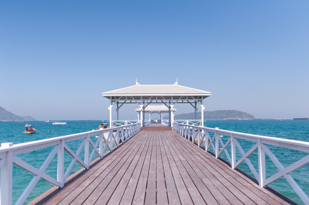 ศาลาสีขาวตั้งอยู่ปลายท่าเรือไม้ที่ยื่นออกไปในน้ำสีคราม มีเรือลำเล็กและภูเขาไกลๆ ท่ามกลางท้องฟ้าสีครามรวม ที่เที่ยวเกาะสีชัง เกาะสวยๆ ในที่เที่ยวชลบุรี ไป เที่ยวเกาะสีชัง เดินทางง่ายๆ ใกล้กรุงเทพแบบไปเช้าเย็นกลับได้ หลีกหนีความวุ่นวาย พร้อมอวดสถานที่สโลว์ไลฟ์
สดใส—เหมาะอย่างยิ่งสำหรับการเที่ยวเกาะสีชังและดื่มด่ำกับวิวเกาะอันเงียบสงบ.