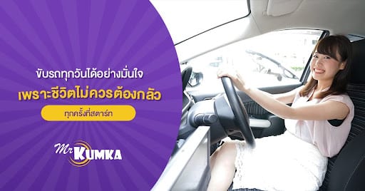 ผู้หญิงคนหนึ่งนั่งอยู่ในที่นั่งคนขับของรถยนต์ ยิ้มให้กล้อง ทางด้านซ้ายมือ มีข้อความภาษาไทยและโลโก้ที่มีชื่อ "คุณกมกา.